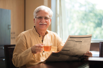 old man with tea and newspaper